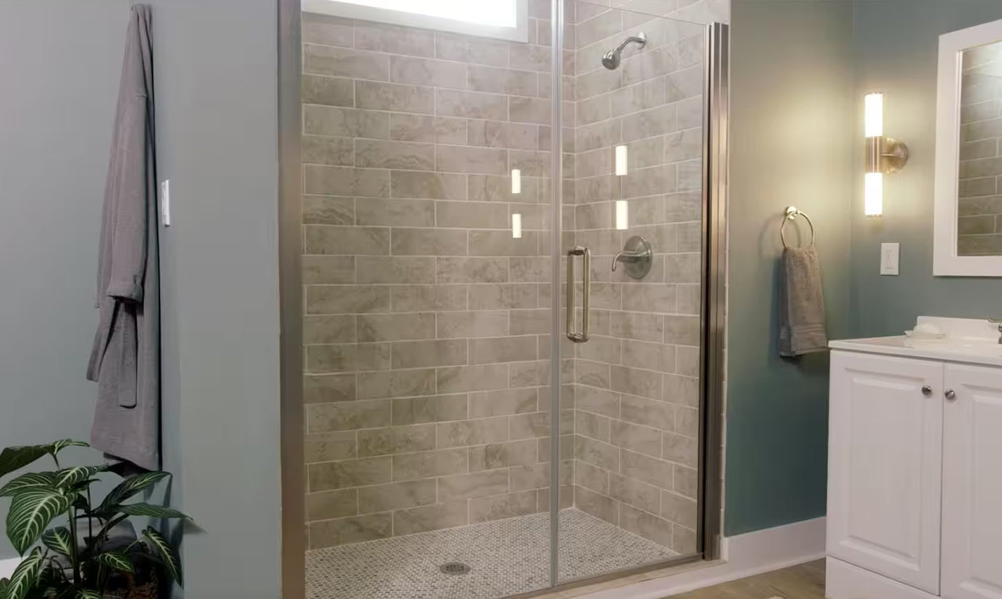 a modern bathroom with a glass-enclosed shower, elegant neutral-toned tiles, and a stylish vanity, creating a cozy and sophisticated atmosphere. | ACE DECOR