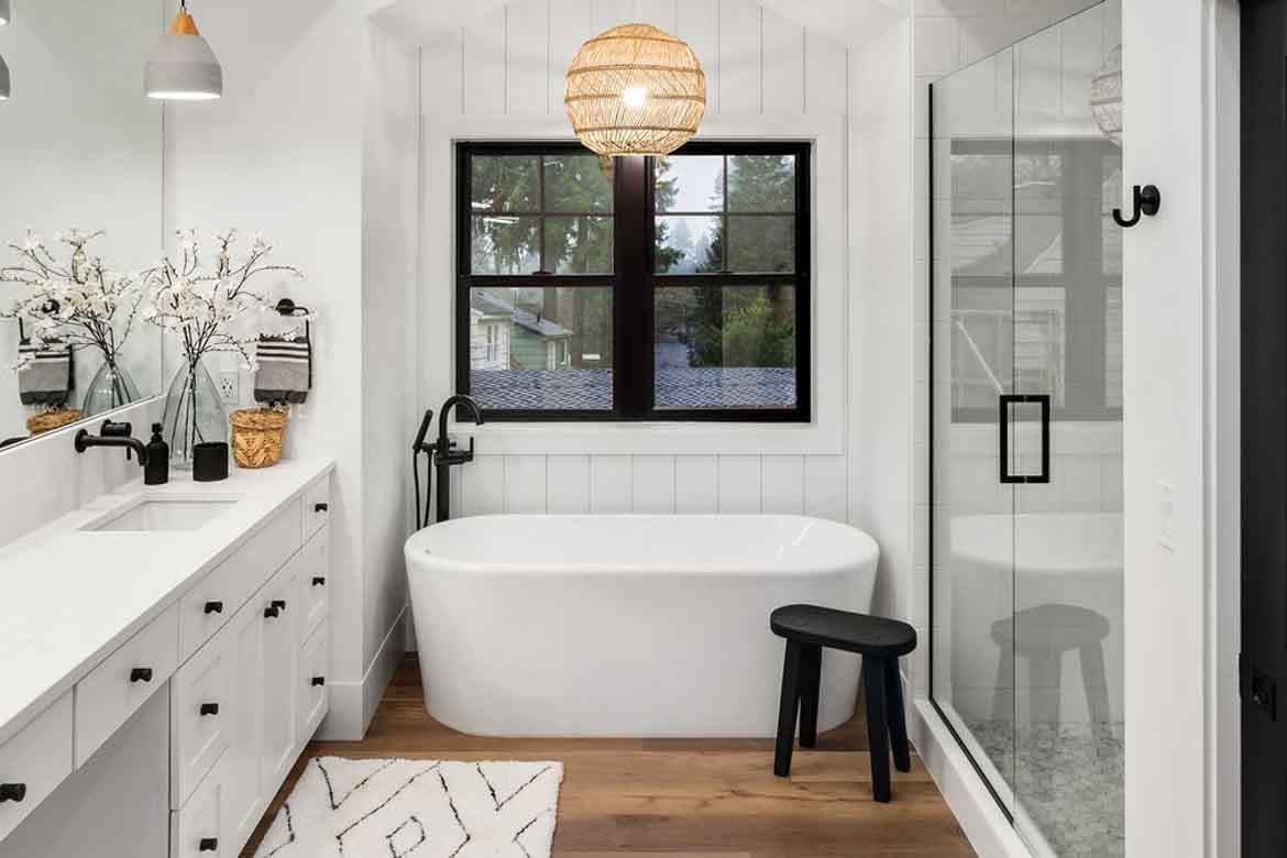 a modern bathroom featuring a sleek freestanding bathtub, natural wood flooring, and stylish black fixtures. | ACE DECOR