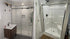 a side-by-side comparison of two different shower enclosures, one with a modern frameless sliding glass door and the other with a traditional framed shower door with built-in seating. | ACE DECOR