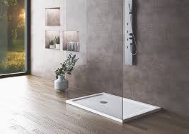 A sleek rectangular shower base with a center drain, set in a modern bathroom featuring wood-look flooring and minimalist decor. | ACE DECOR