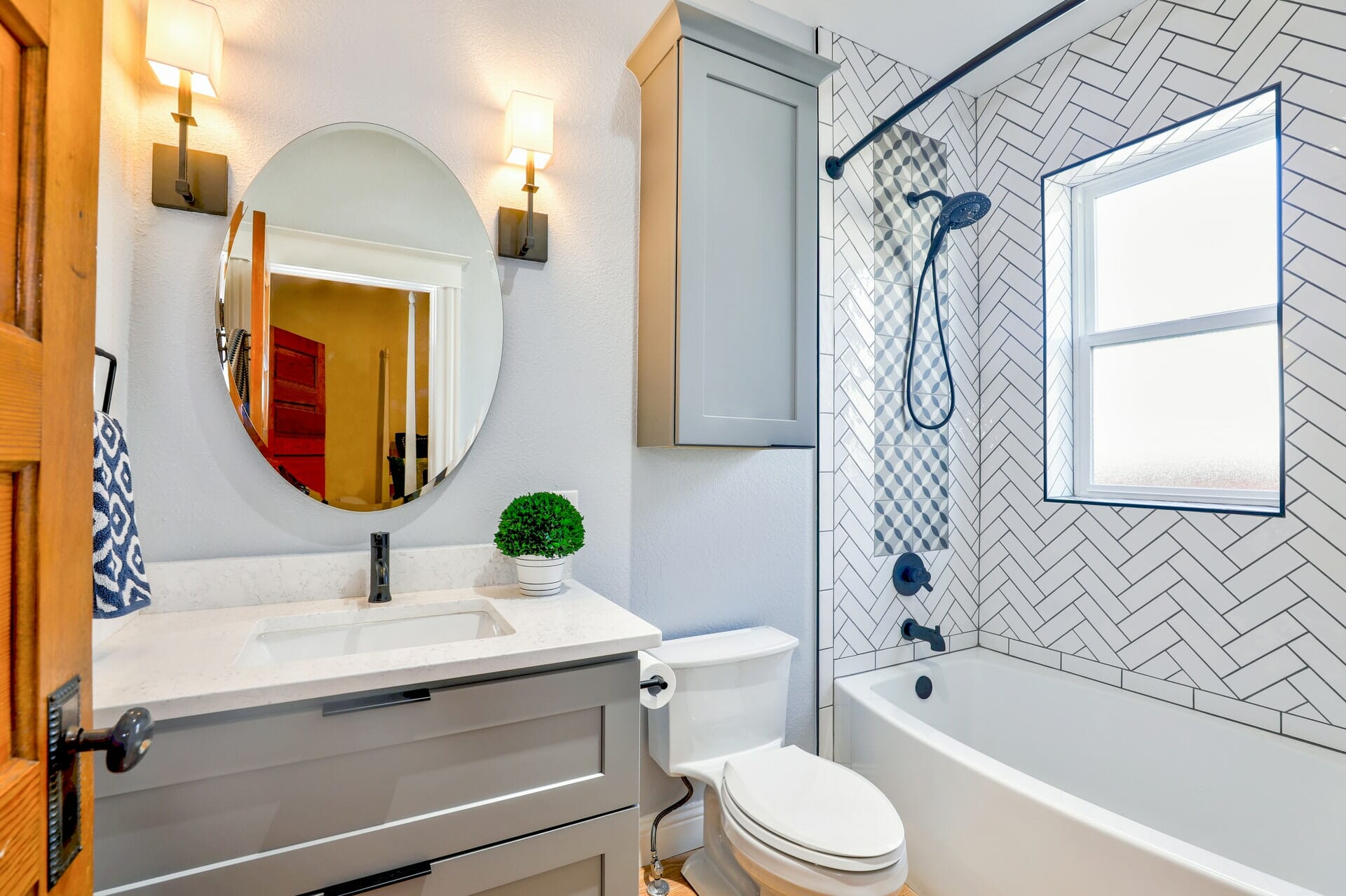 an oval mirror in a small but clean bathroom | ACE DECOR