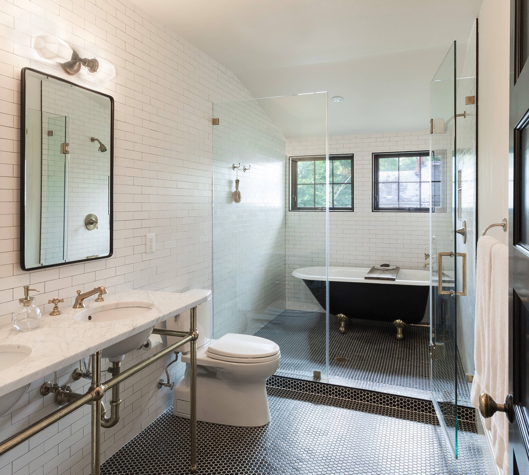 a stylish bathroom featuring a clawfoot bathtub inside a glass shower enclosure. | ACE DECOR
