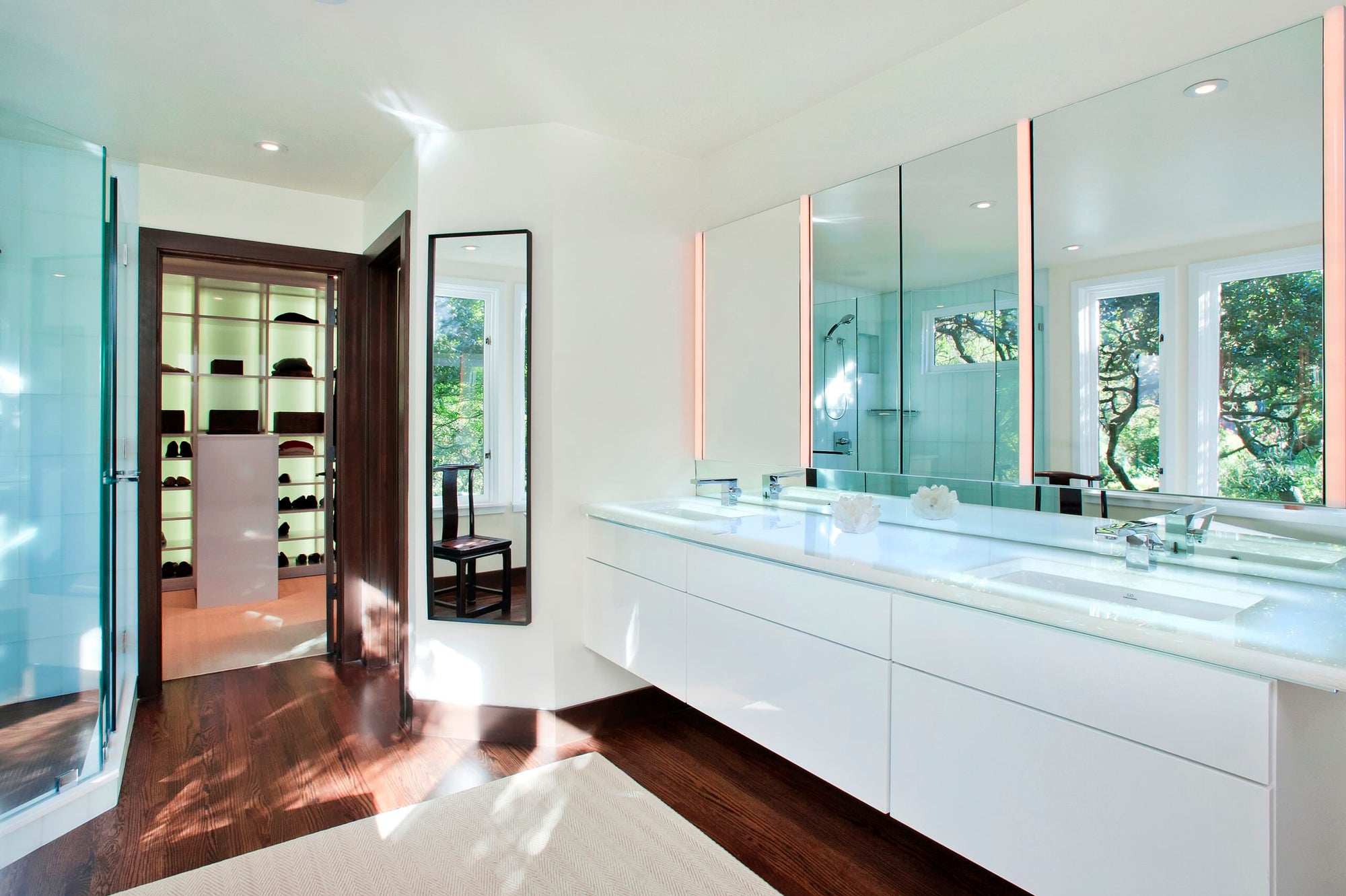 A bright, modern bathroom featuring a sleek recessed medicine cabinet with mirror above a double sink vanity, complemented by natural light and wooden flooring. | ACE DECOR