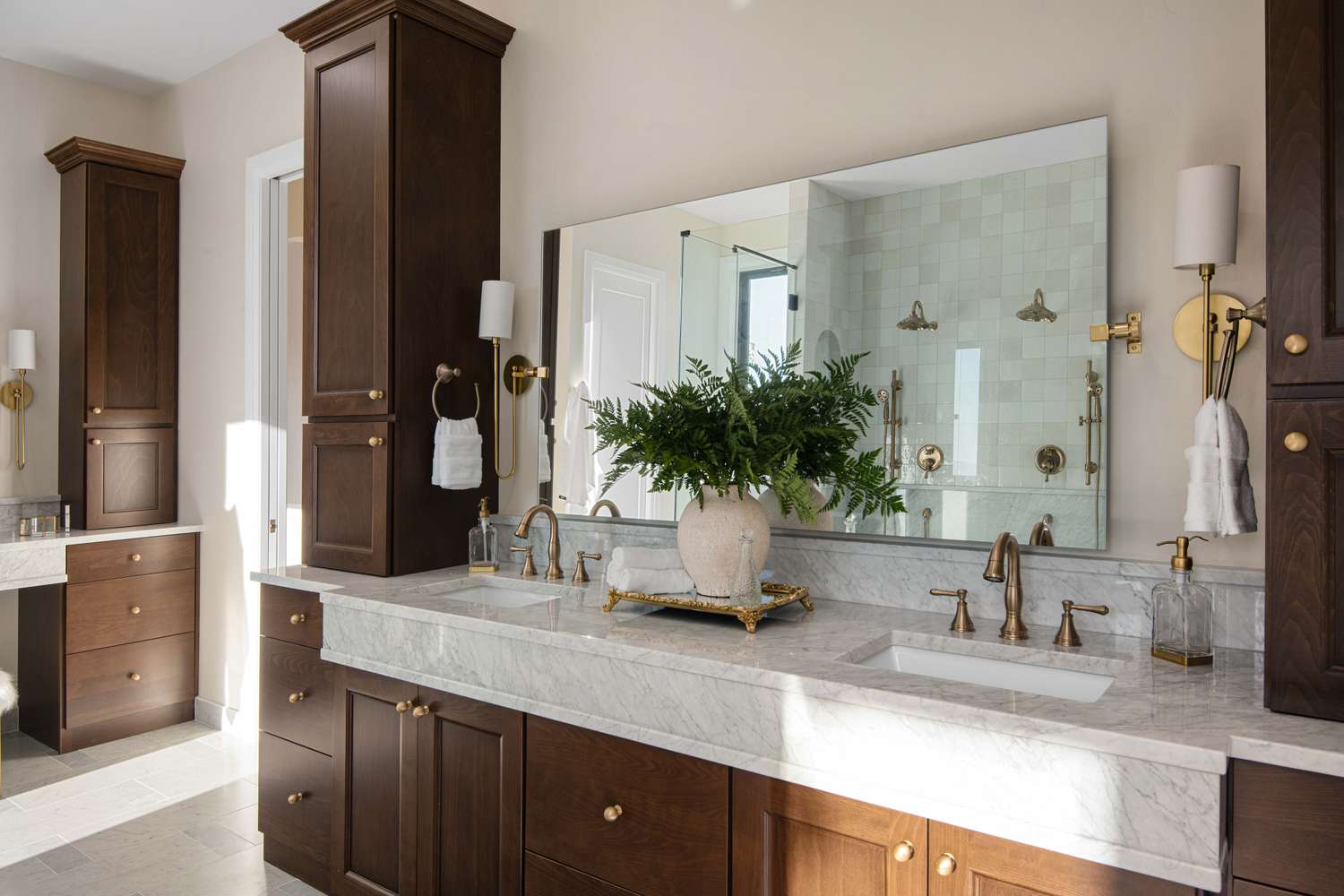 A high-end bathroom vanity with dark wood cabinetry, marble countertops, and brass fixtures, exuding luxury and elegance. | ACE DECOR