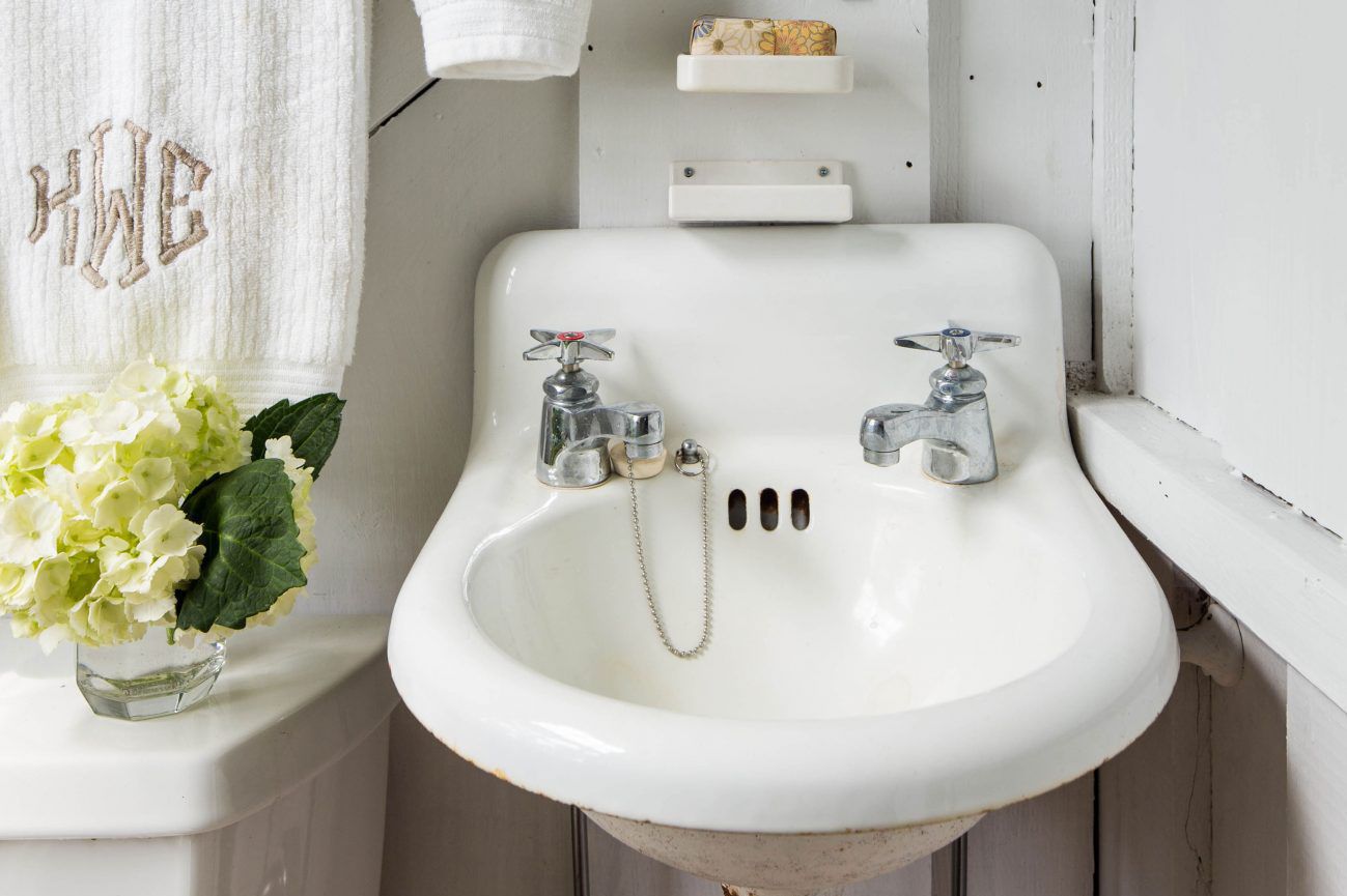 A vintage white sink with two faucets. | ACE DECOR