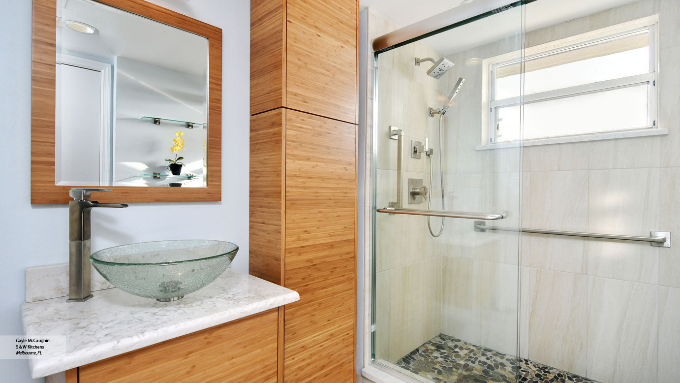 a modern bathroom with a glass sliding shower door, a sleek vessel sink, and warm wooden cabinetry, creating a stylish and functional space. | ACE DECOR