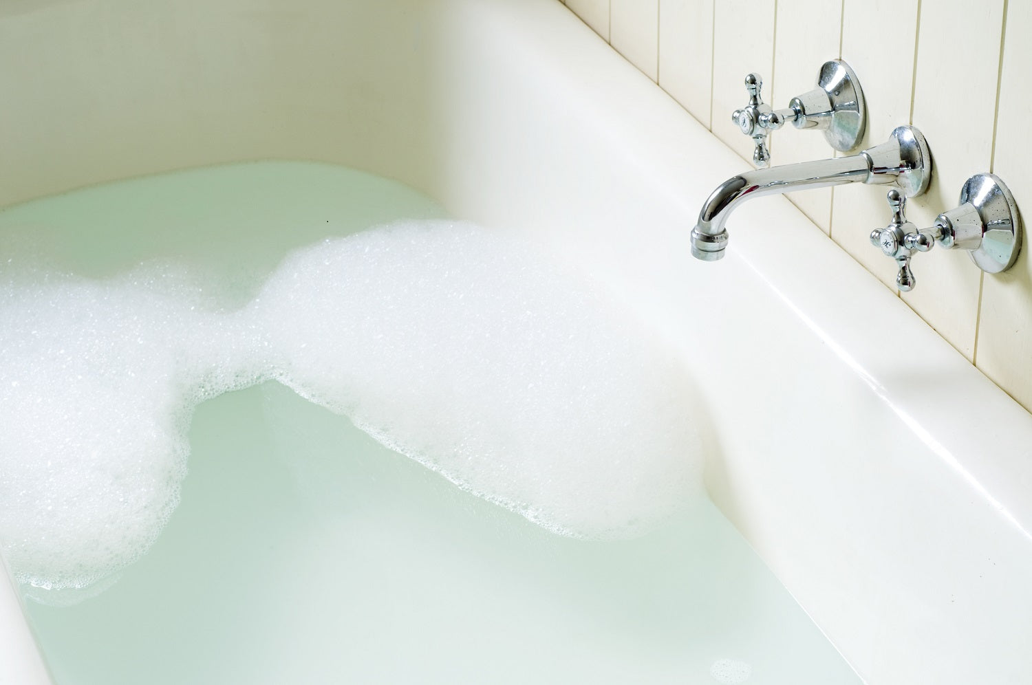 A bathtub filled with water and bubbles, ready for a relaxing soak. |ACE DECOR