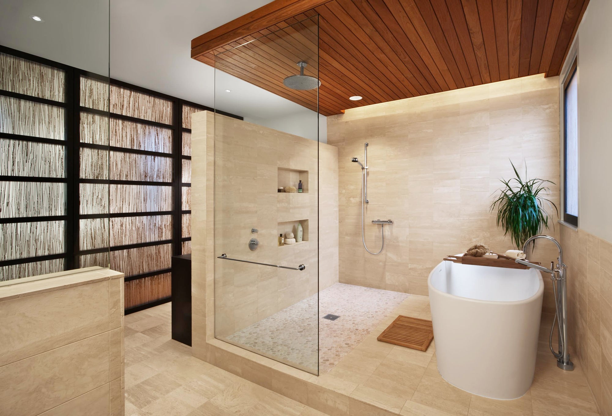 A modern, spa-inspired bathroom featuring a frameless bath shower enclosure, freestanding tub, and natural wood accents | ACE DECOR