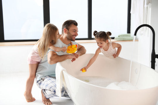 A family enjoys bath time together with rubber ducks in a fiberglass composite bathtub. | ACE DECOR