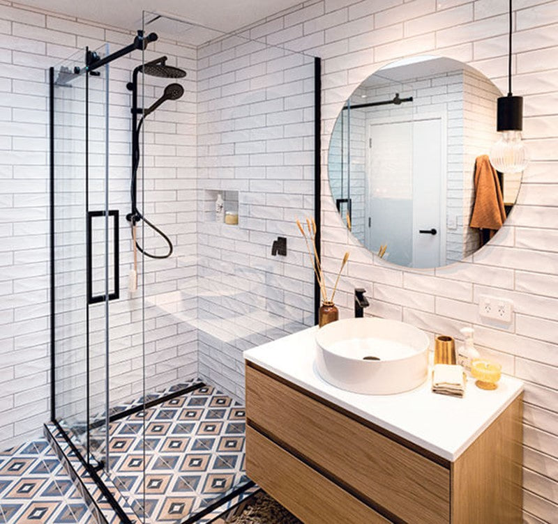 a stylish bathroom with a frameless sliding shower door, a modern floating vanity, geometric floor tiles, and elegant black fixtures for a sleek, contemporary look. | ACE DECOR