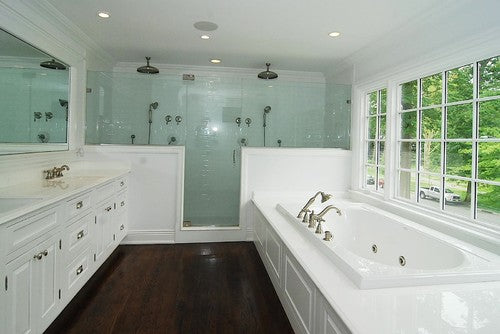 a spacious bathroom with door and panel shower doors, a luxurious bathtub, and large windows offering natural light. | ACE DECOR