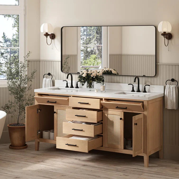 A double bathroom vanity with two drawers and an open cabinet underneath, light wood finish, white marble top surface, black faucet and chrome fixtures, a large mirror above the sink in a wicker style, in a modern farmhouse setting. | ACE DECOR