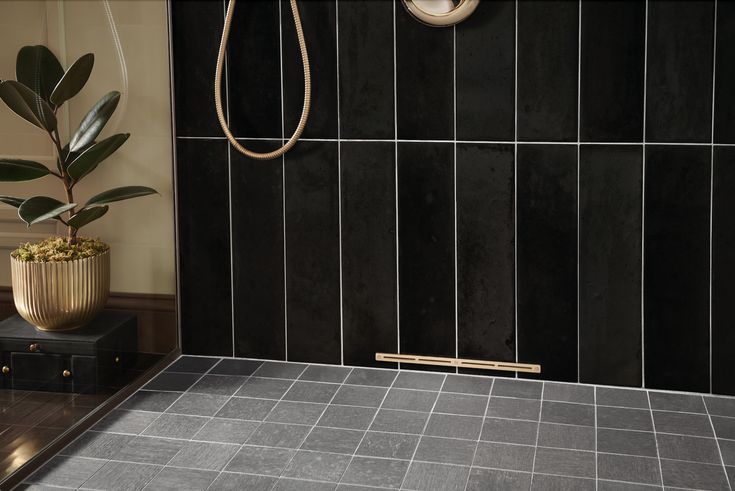 Shower drying system installed in a stylish bathroom with dark tiles and a metal drain