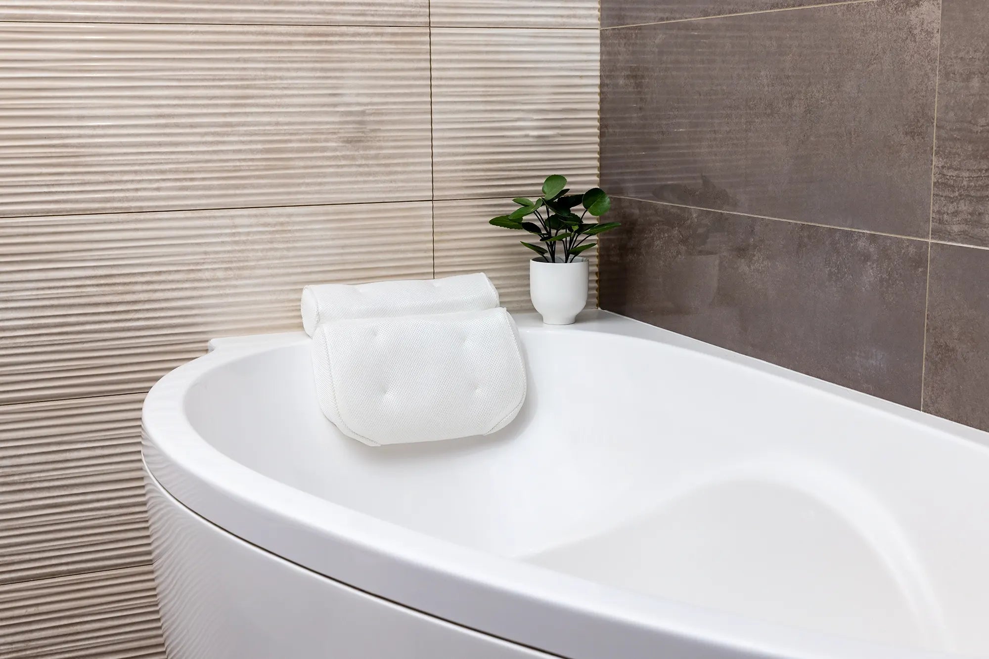 A comfortable bathtub pillow placed on the edge of a modern bathtub for relaxation