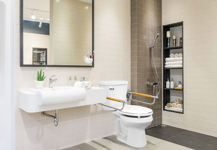 Modern bathroom with an accessible design, featuring a toilet and shower setup, ideal for basement toilet and shower pump system installation in functional spaces