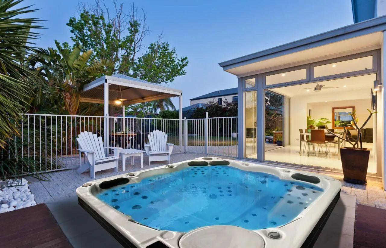 Luxurious outdoor patio with bubbling hot tub, modern glass house, Adirondack chairs, twilight garden, serene ambiance