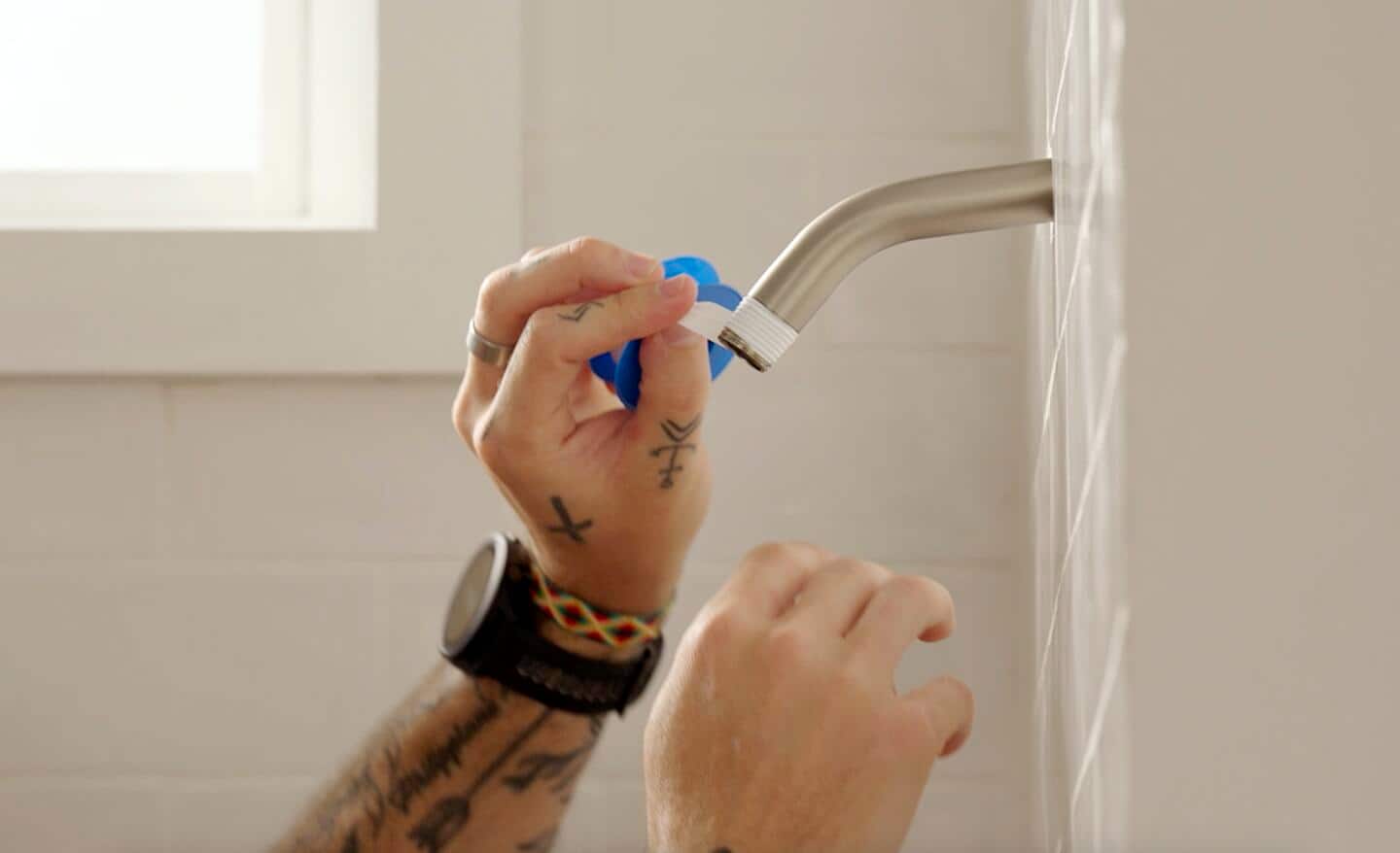 Wrapping tape for shower head on a brushed nickel shower arm during installation