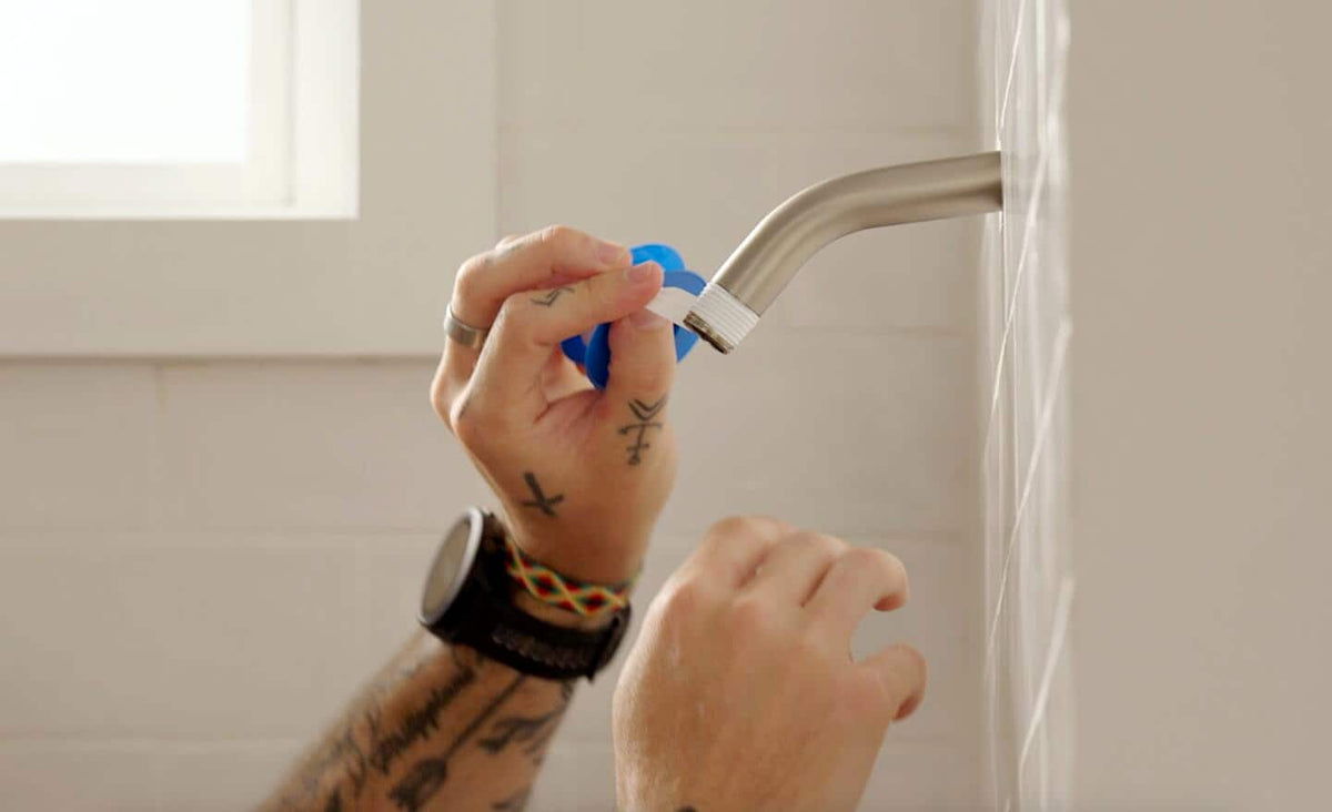 Wrapping tape for shower head on a brushed nickel shower arm during installation