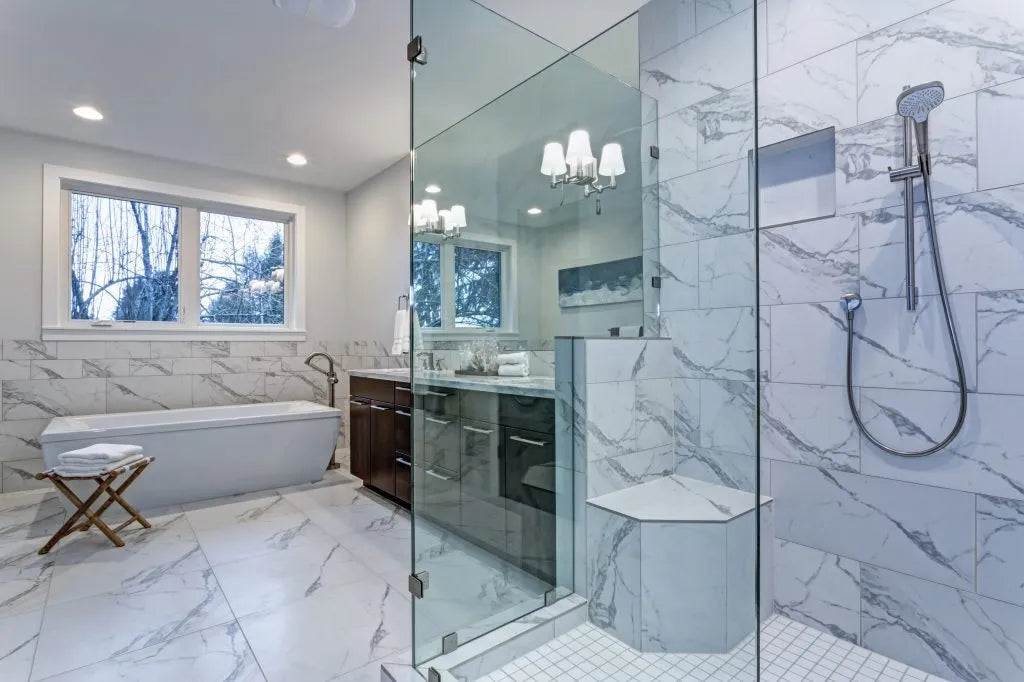Luxurious bathroom with marble tile and walk-in shower enclosed by no frame glass shower doors
