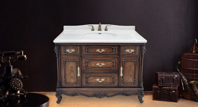 Victorian-style antique bathroom vanity cabinet with ornate wood carvings and marble top