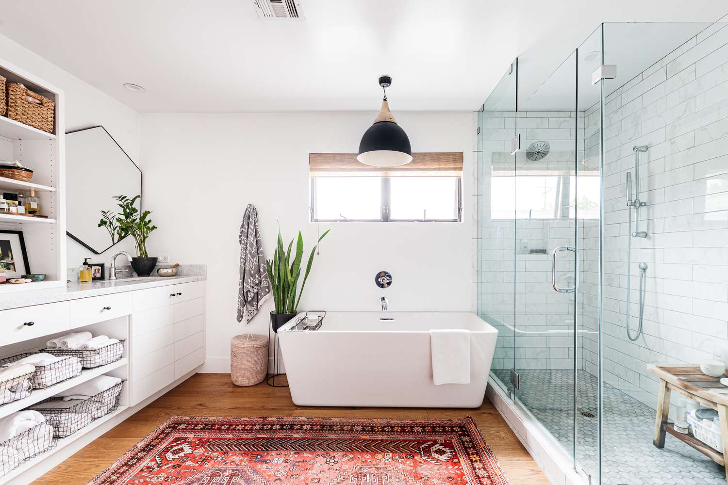 Bright modern bathroom featuring a glass walk-in shower doors with white subway tiles and minimalist design.