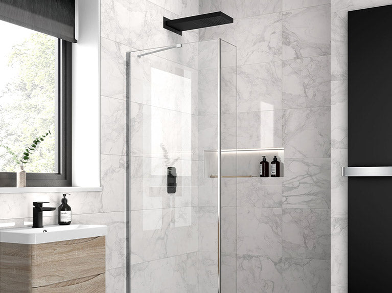 Modern bathroom with hinged glass shower doors and panels paired with matte black hardware.