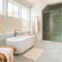 Modern minimalist bathroom featuring freestanding bathtub and glass shower door.