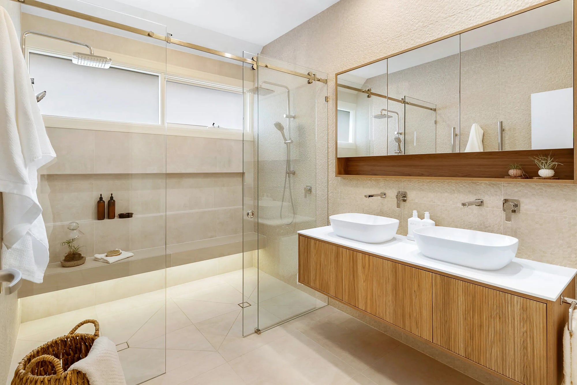 Modern frameless shower door with light beige tiles in minimalist open bathroom creating spacious neutral ambiance.