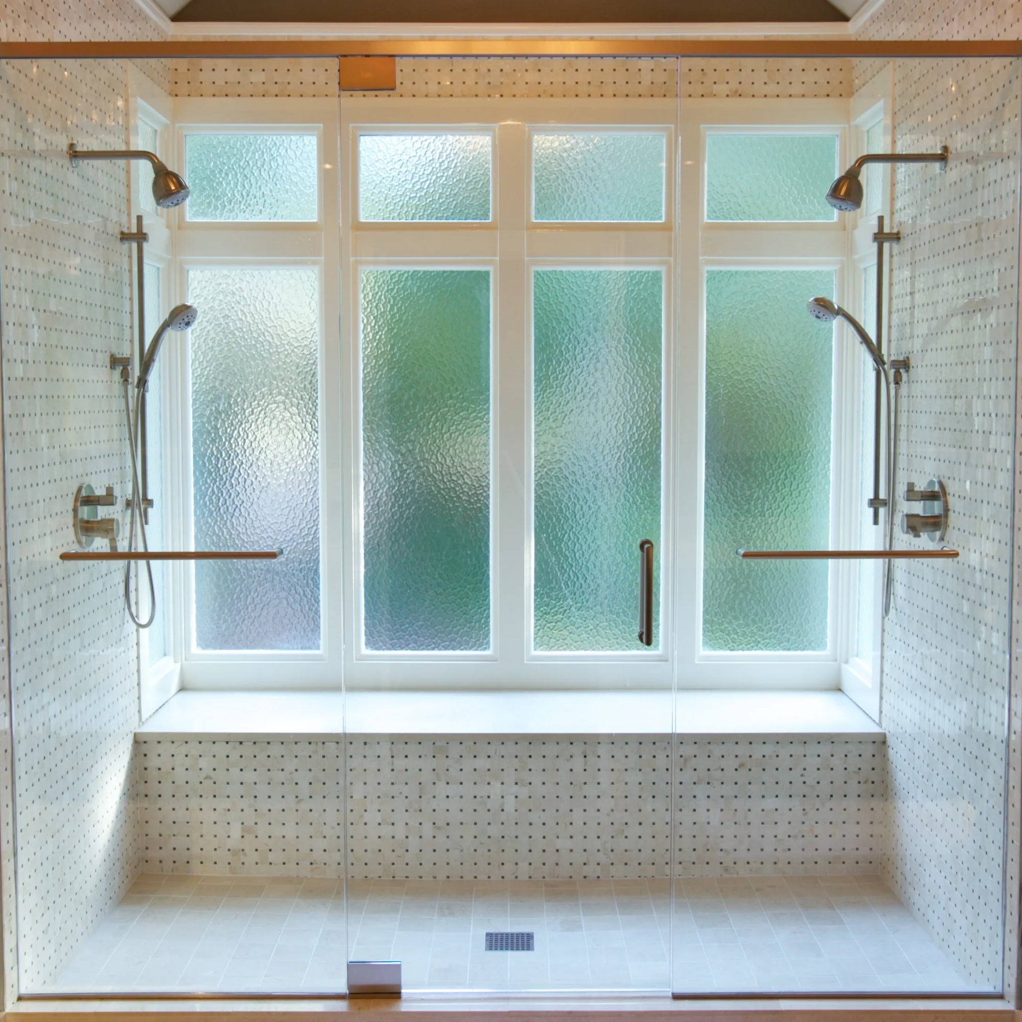 Modern 2 person shower room with dual shower systems, frosted glass window, chrome fixtures, and built-in tiled bench.