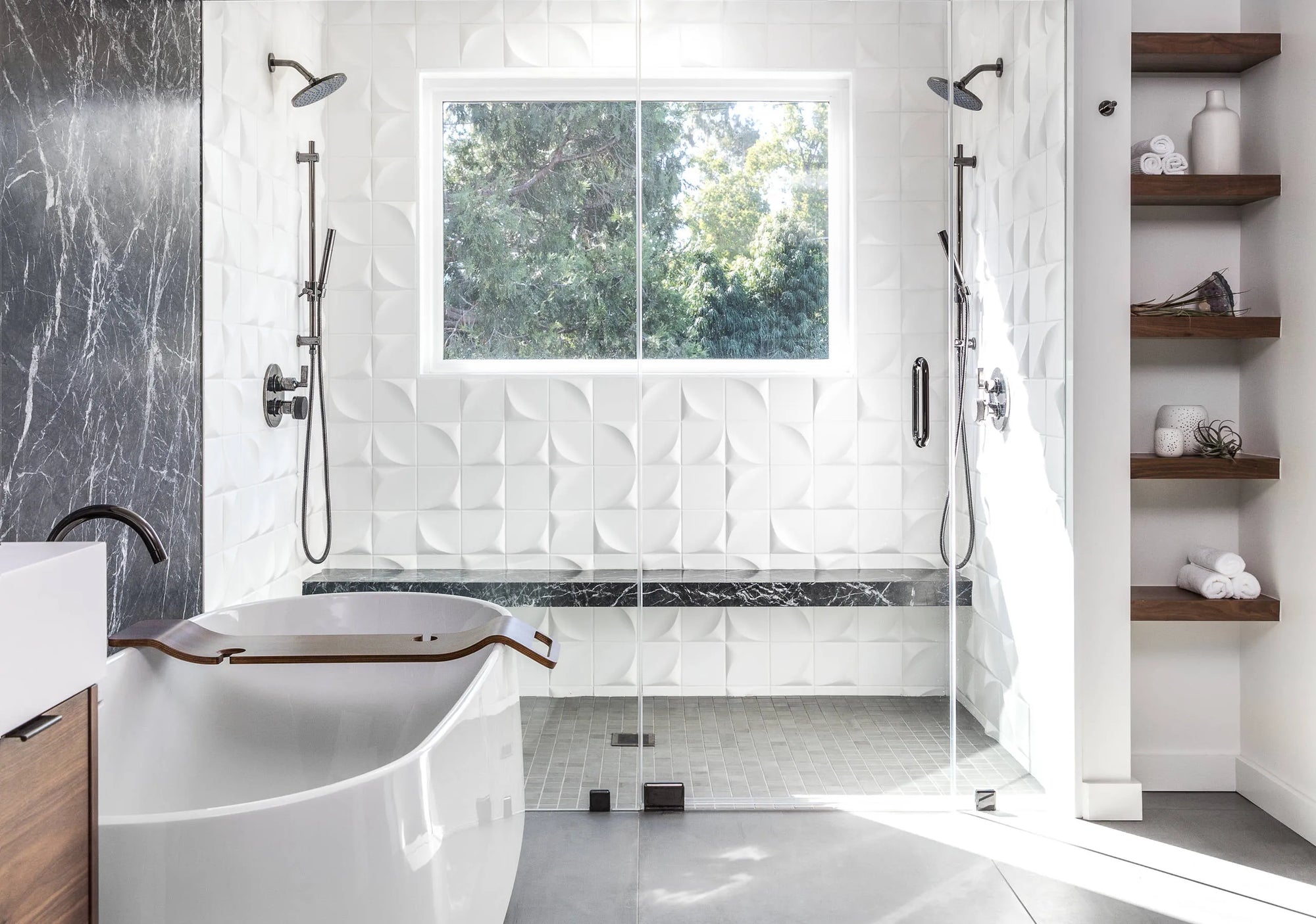 Freestanding white bathtub in modern luxury bathroom with shower, natural light and wooden accents.