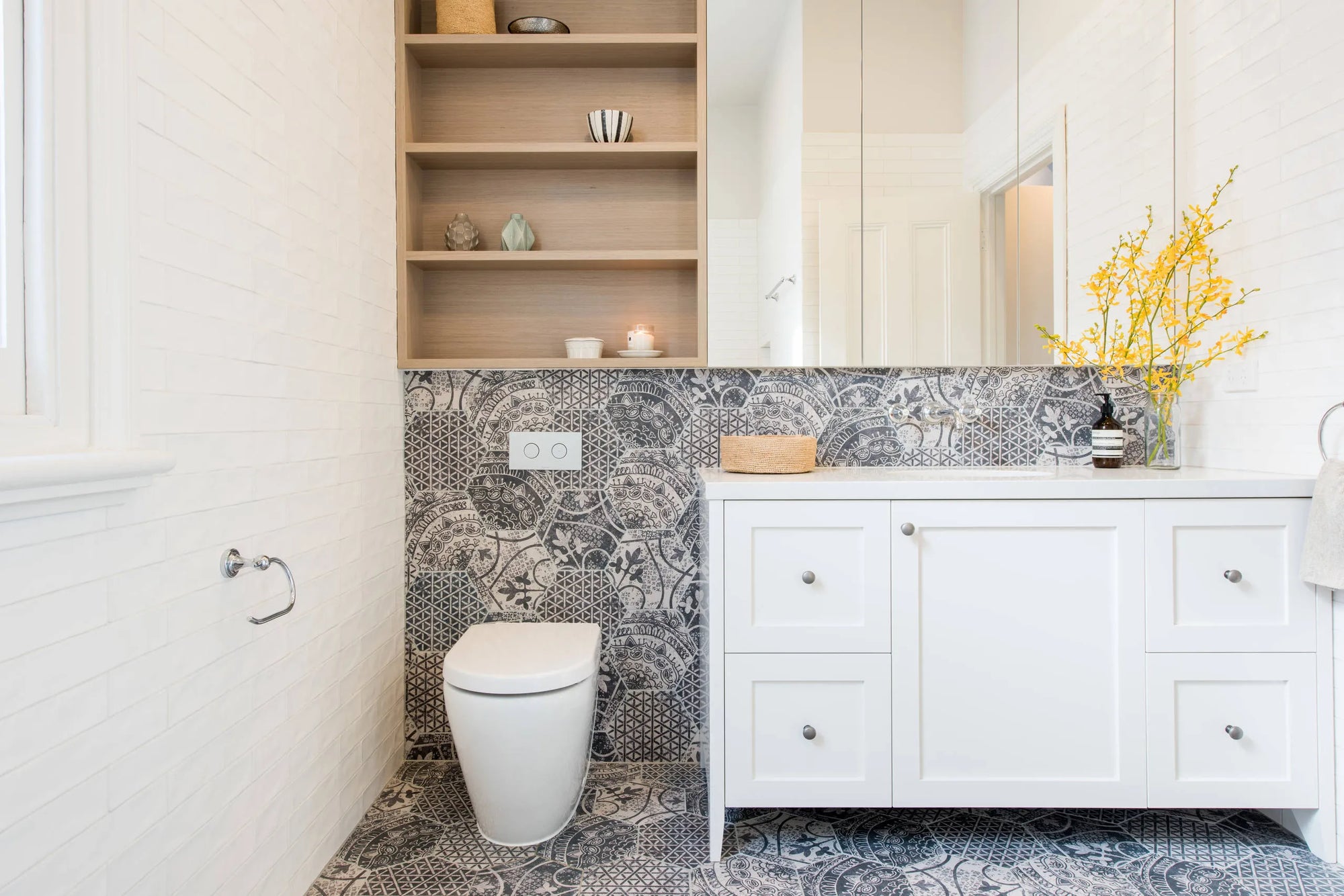 Modern white Toilet in contemporary bathroom with floral accent and textured tile feature wall.