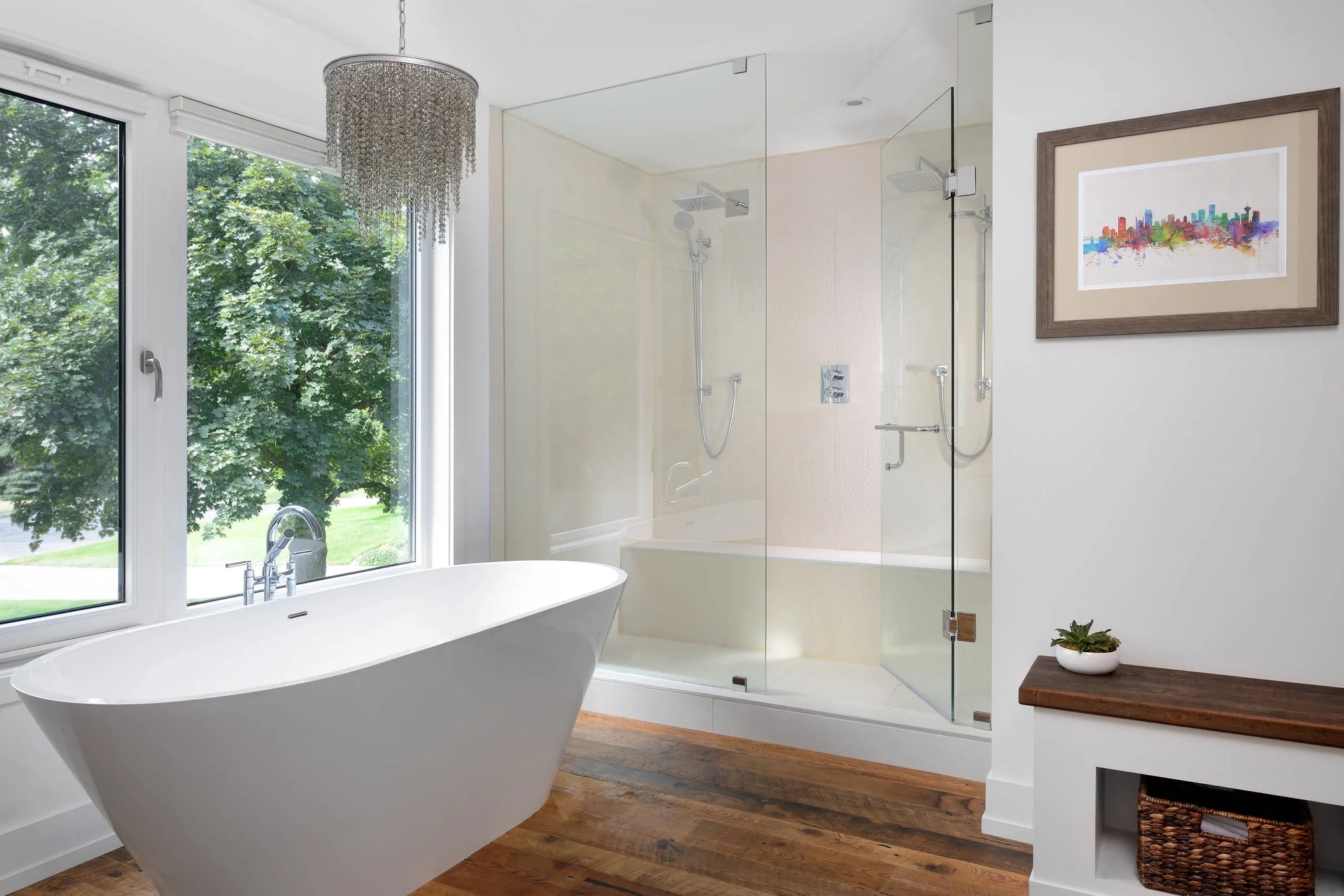 Modern freestanding white bathtub in a luxurious bathroom with large windows overlooking lush greenery.