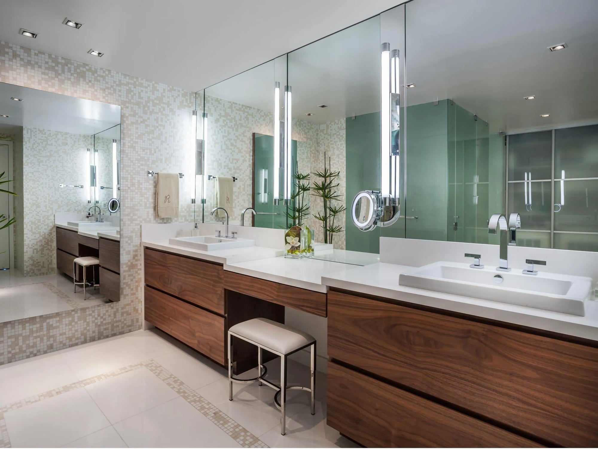 Modern bathroom with a large bathroom mirror above a double vanity, glossy green cabinetry, and minimalist aesthetic.