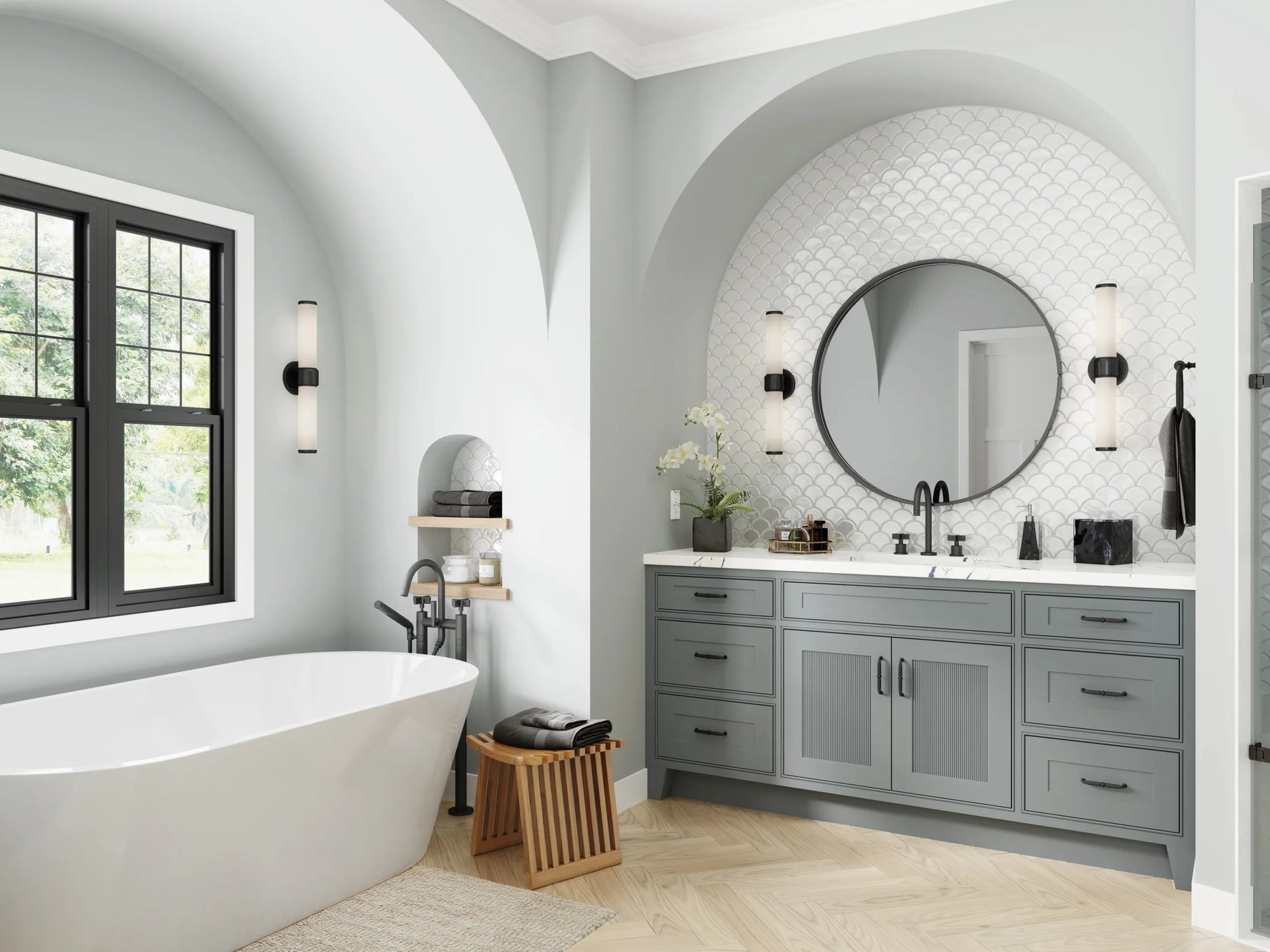 Large freestanding tub in a modern bathroom with herringbone tile walls, wooden floors, and natural light.