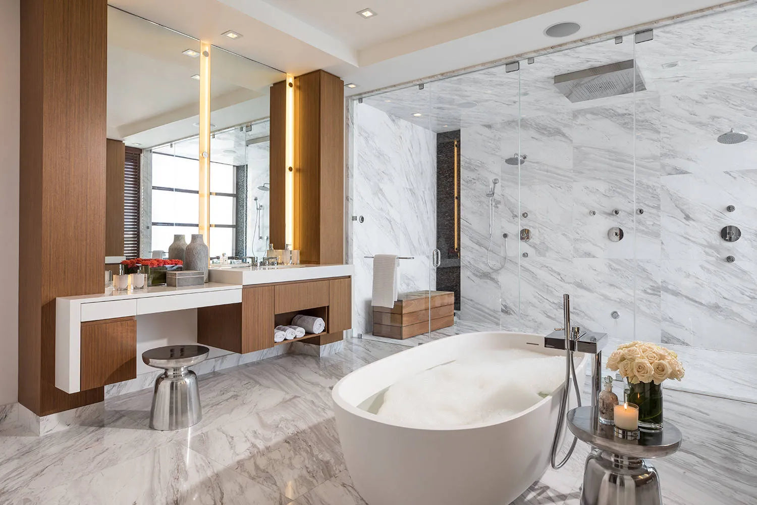 Luxurious modern bathroom with freestanding tub, marble finishes, and a multi-head shower enclosure.