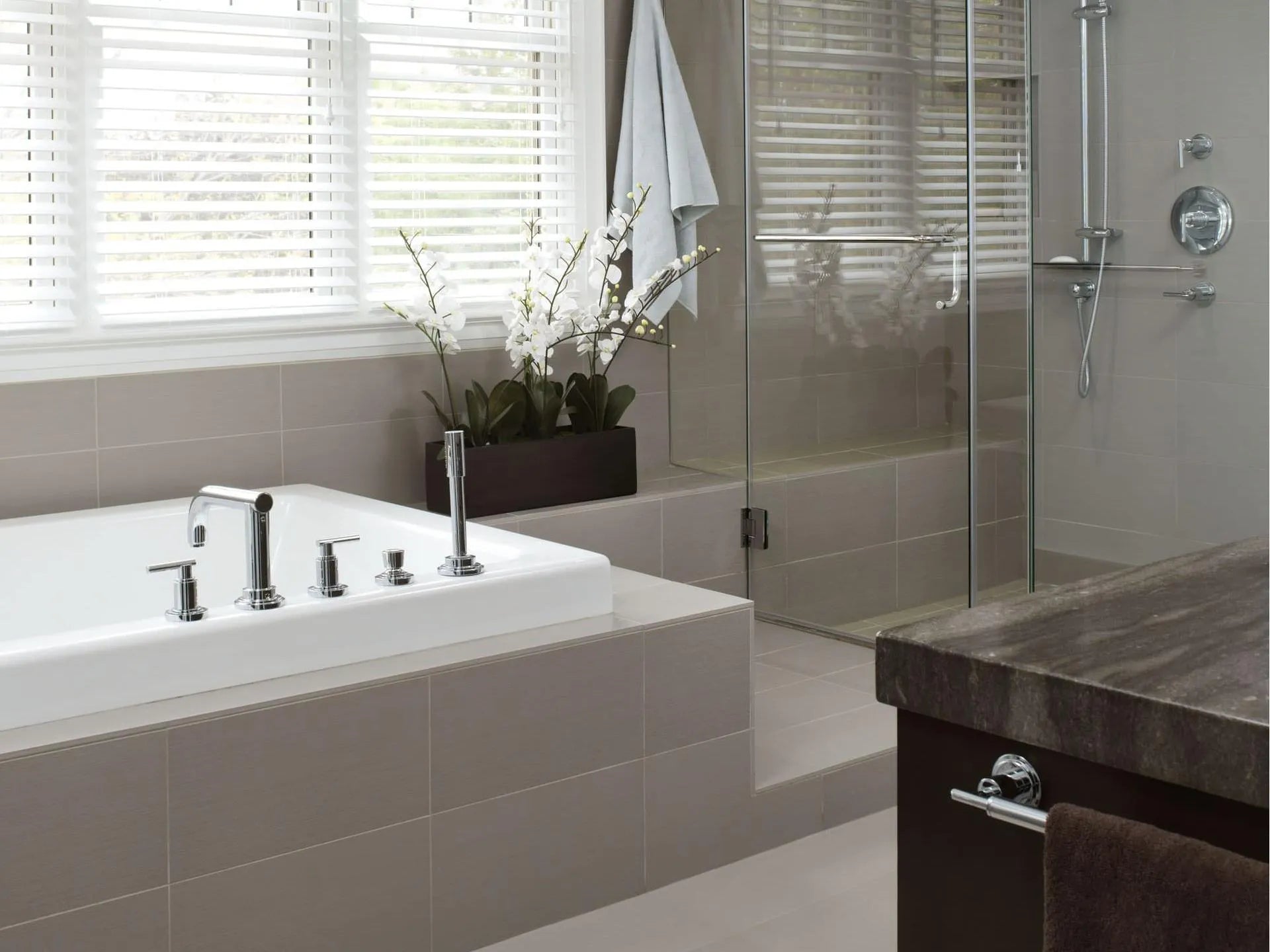 Modern bathroom with a 3 Handle Bathtub and Shower Faucet, rainfall shower, dark wood vanity, and white orchids in a spa-like setting.