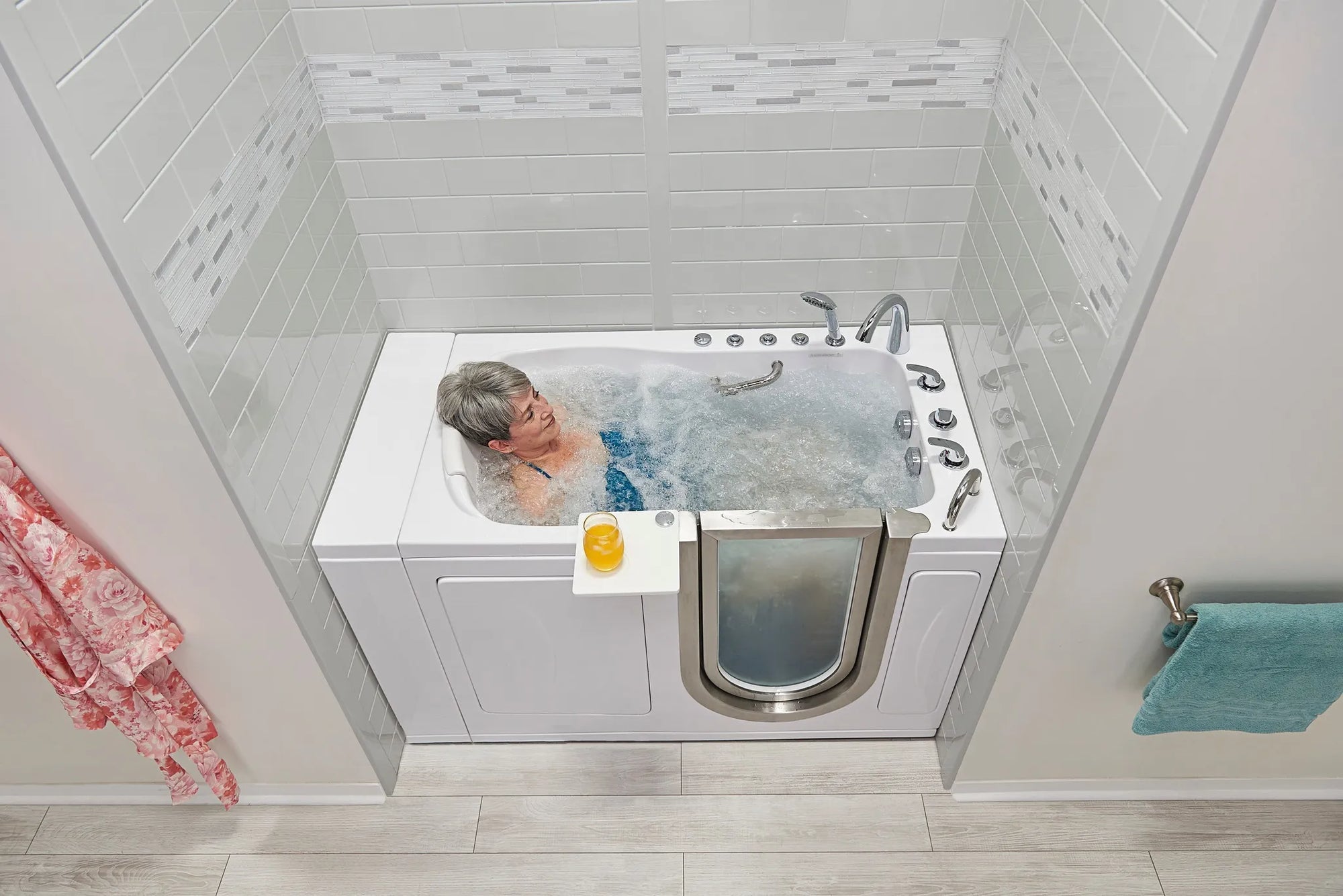 Elderly person relaxing in a walk-in tub for elderly with air-jet bubbles and low-threshold door in a modern bathroom.