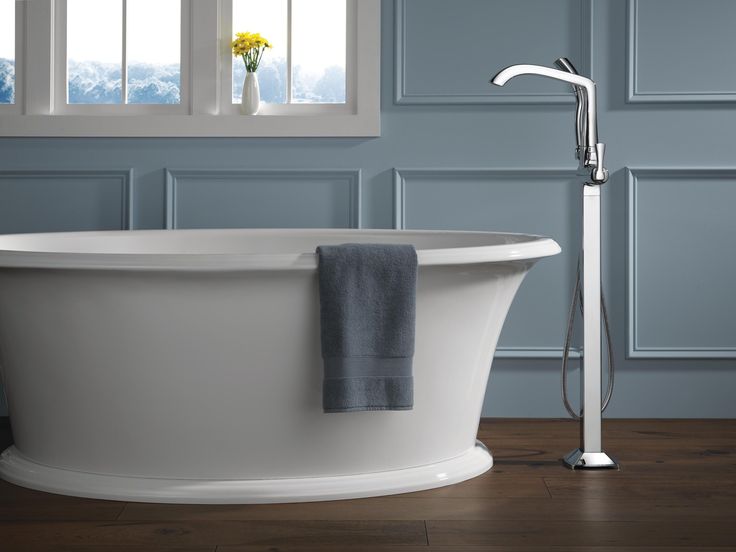 Chrome one handle freestanding bathtub faucet with hand shower.