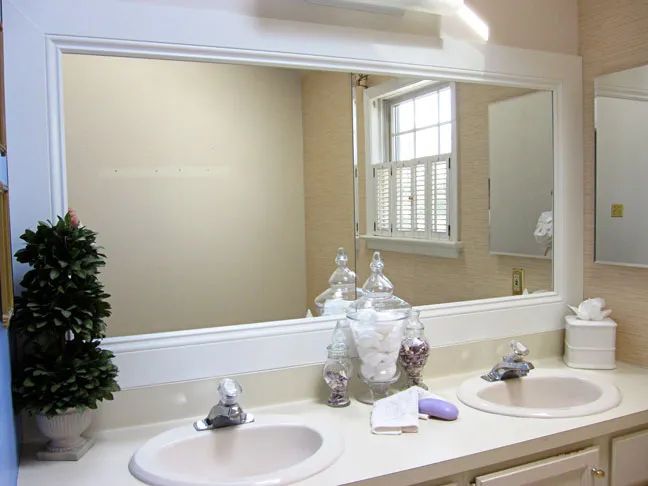 White wood molding for mirror in bathroom above double sink vanity