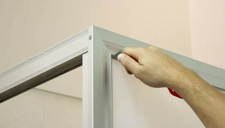 Close-up of a shower door frame being painted, can you paint shower door frames with proper preparation.