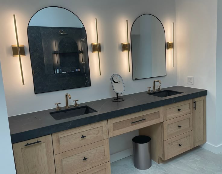 Contemporary bathroom mirror ideas for double vanity with rounded mirrors and sleek black countertops