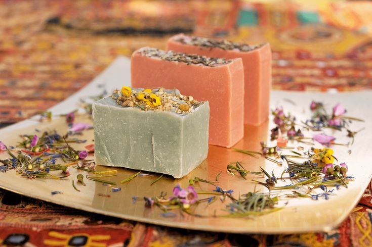 Artisan handmade soap bars with floral toppings on decorative plate
