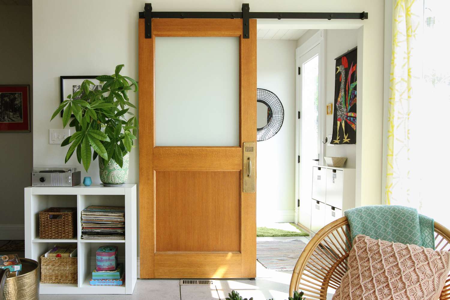 A wooden barn style door with frosted glass panels and black hardware, adding a modern touch to a living space