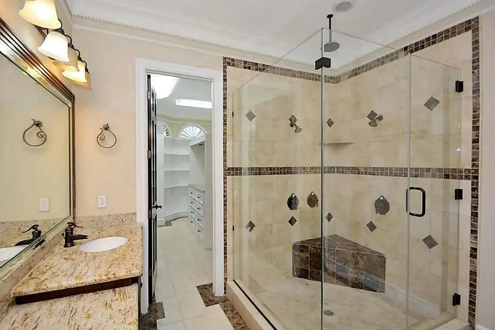 Spacious luxury bathroom featuring a glass single sliding shower door with dark tile accents