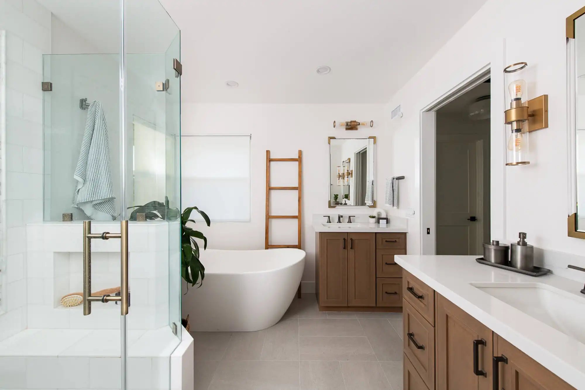 Modern craftsman bathroom with glass shower, freestanding tub, and wood vanities