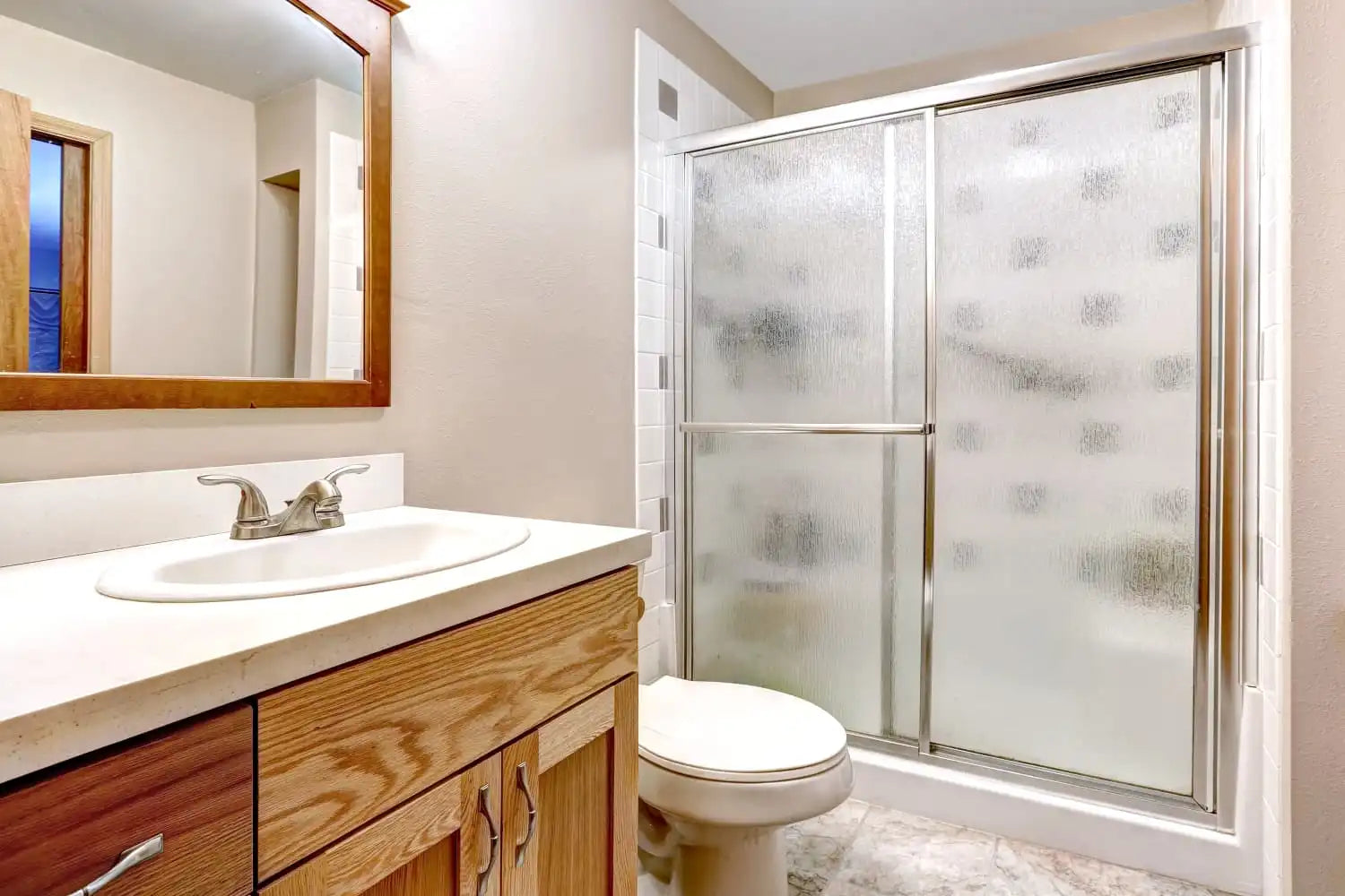 Bathroom featuring framed shower sliding doors with frosted glass for privacy.