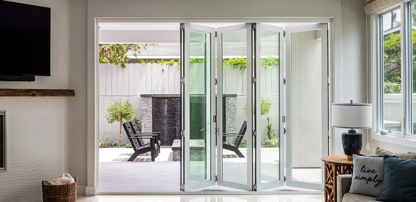 Modern white bifold patio doors fully opened, demonstrating a standard patio door size for spacious indoor-outdoor transition.