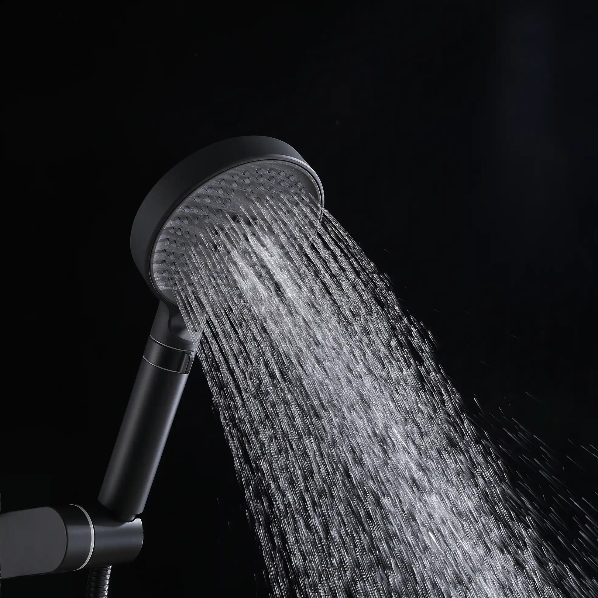 Auralen matte black handheld shower head delivering a mixed spray pattern.