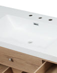 Close-up of SMC bathroom sink with white countertop and natural wood vanity drawer | Ace Decor