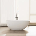 Aura Series 59" solid surface soaking bathtub with ultra-thin edge in a modern bathroom with sleek chrome tub faucet.